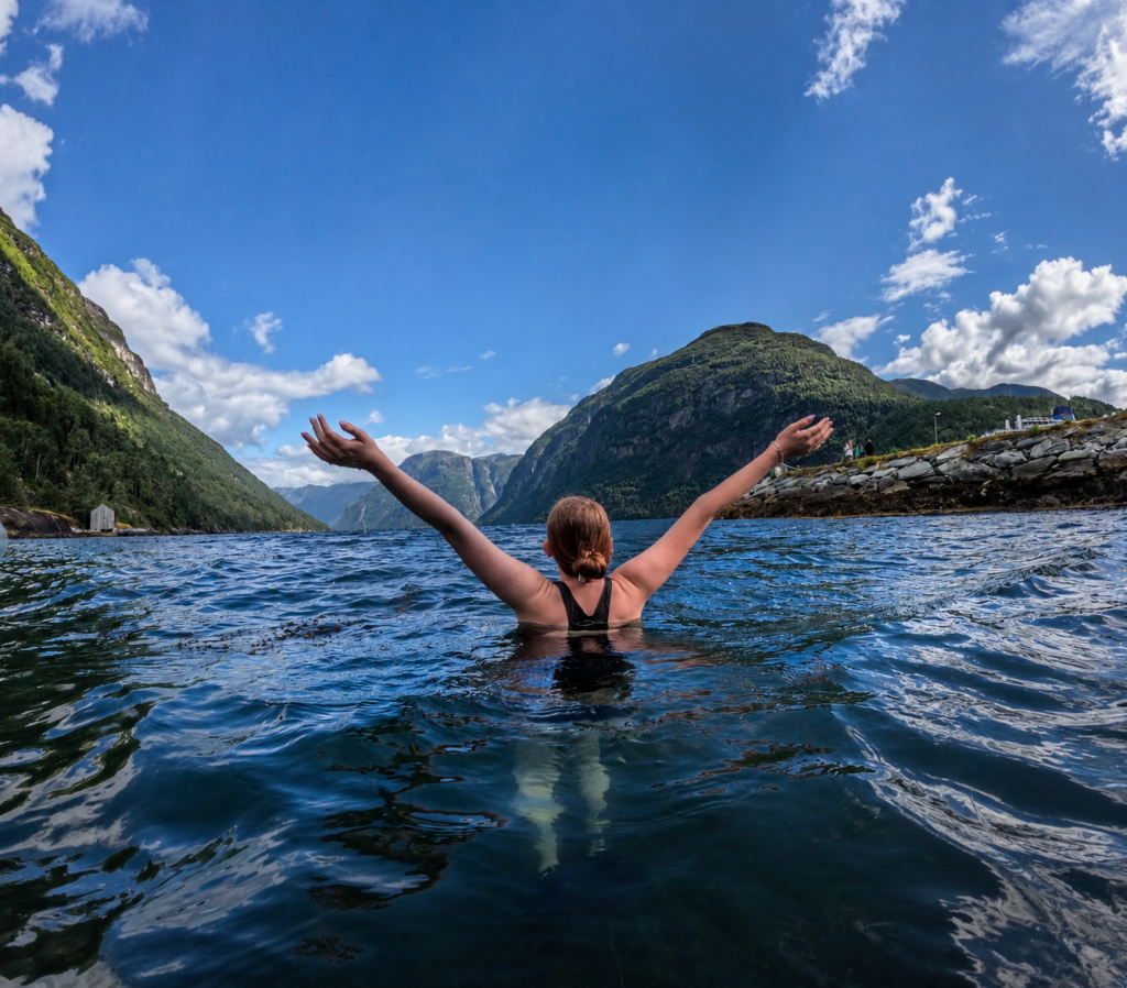 Family wild swimming in the Norwegian fjord at Hellesylt Badehus